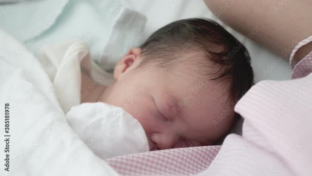 Close up shot of a newborn baby sleeping next to the body heat of the mother. Close up shot of a newborn baby sleeping next to the body heat of the mother.