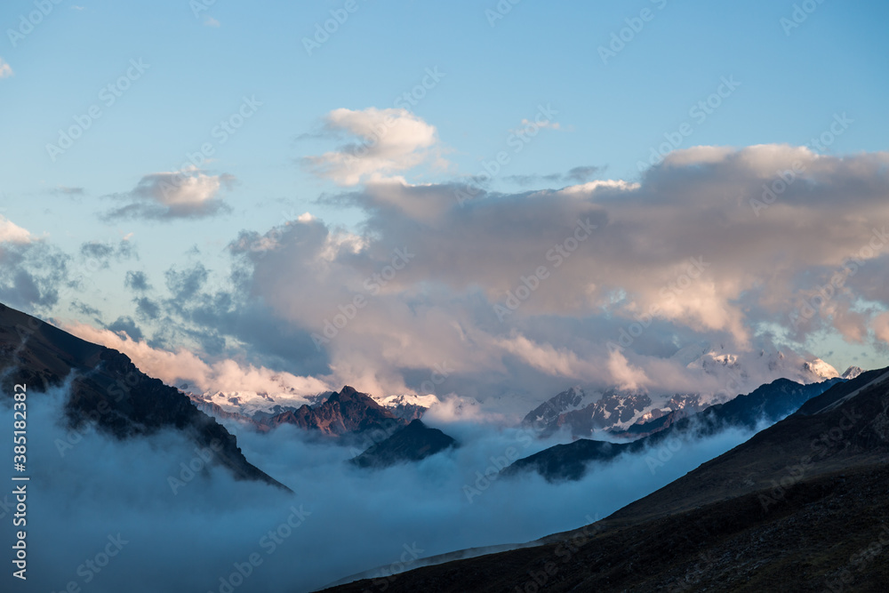 Nevados y montañas andinas con cielo azul 
