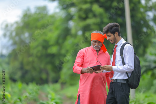 Indian farmer disscuss with agronomist at field photo