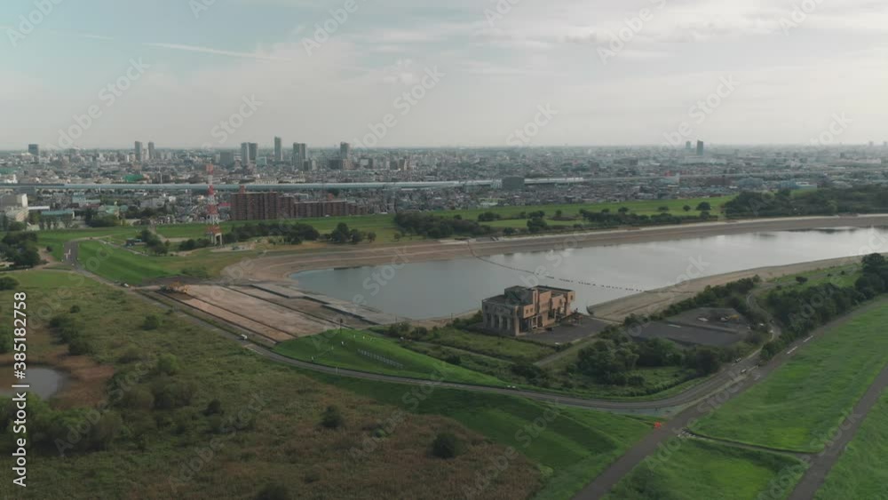Arakawa River Overlooking The Saitama City With Berm And A Flood Control In The Foreground In Saitama, Japan. - aerial drone shot Arakawa River Overlooking The Saitama City With Berm And A Flood Control In The Foreground In Saitama, Japan. - aerial drone shot