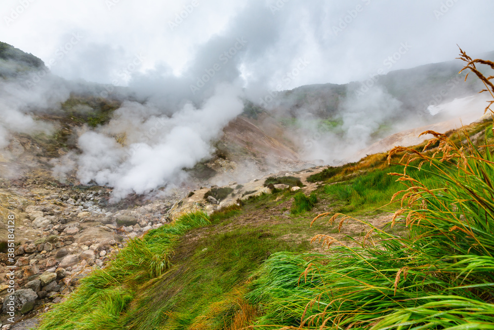 Thrilling view of volcanic landscape, aggressive hot spring, erupting fumarole, gas-steam activity in crater of active volcano. Scenery mountain, travel destinations for hike, active vacation.