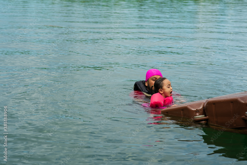 Asian family swimming at the Kenyir Lake, Malaysia.