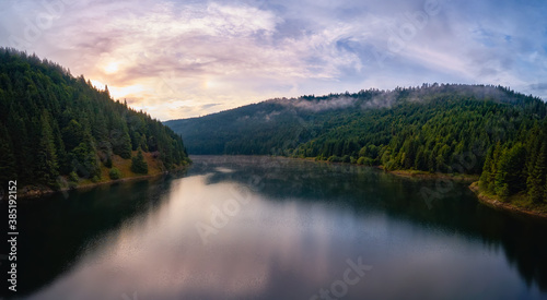 Aerial view clouds over the forest and lake at sunrise. View from drone. Aerial top view cloudscape. Transylvania  Romania 