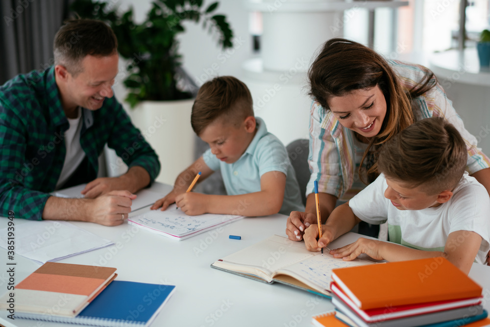 Parents helping the kids with their homework. Litlle boys learning at home... Parents helping the kids with their homework. Litlle boys learning at home...
