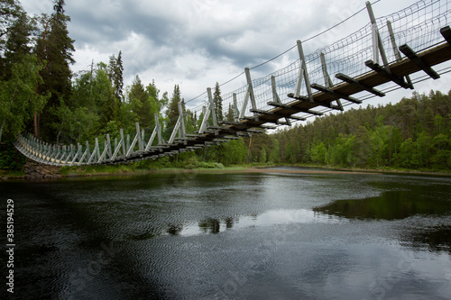 Suspension bridge crossing the River Kitkajoki at Oulanka National park, Northern Finland photo