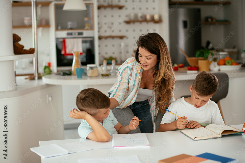 Mother helping her son with homework at home. Little boy learning at home... Mother helping her son with homework at home. Little boy learning at home...