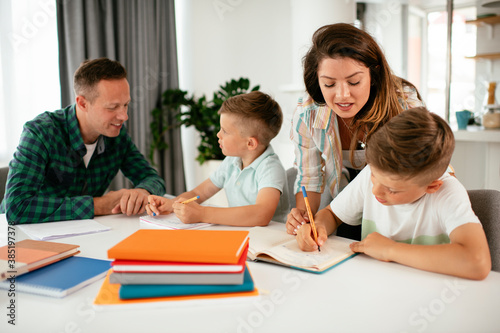 Parents helping the kids with their homework. Litlle boys learning at home...