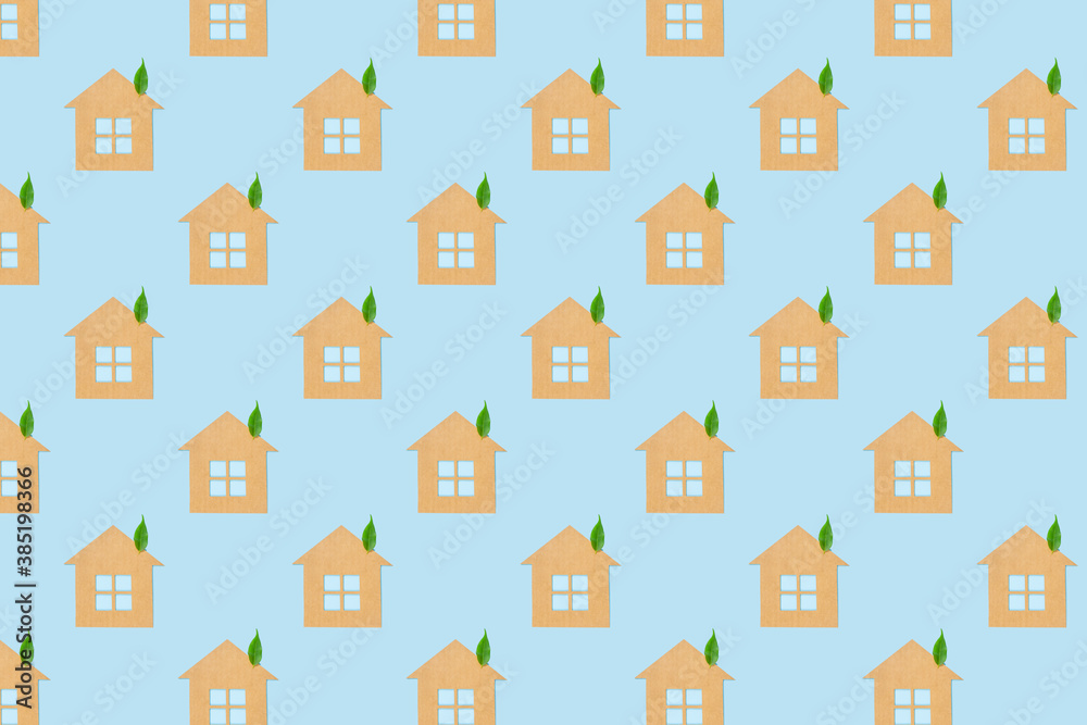 Houses made of craft paper and green leaves of a plant on a light blue background. Eco-friendly home concept, healthy lifestyle, zero waste... Houses made of craft paper and green leaves of a plant on a light blue background. Eco-friendly home concept, healthy lifestyle, zero waste...