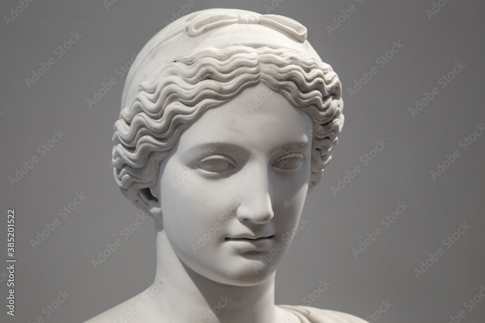 Ancient white marble sculpture head of young woman. Statue of sensual renaissance art era naked woman antique style