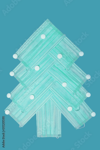 isolated Christmas tree made of masks and pills on blue background