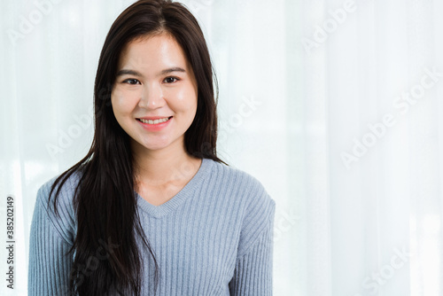 Close up headshot portrait young Asian happy beautiful woman healthy smiling face long hair, studio shot looking to camera at home and have a copy space for your text