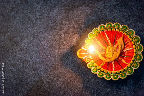 Top view overhead clay lit light a fire already on Diya or oil lamp, studio shot on concrete background, Decoration of Hinduism rangoli, Happy celebration Deepavali or Diwali festival concept