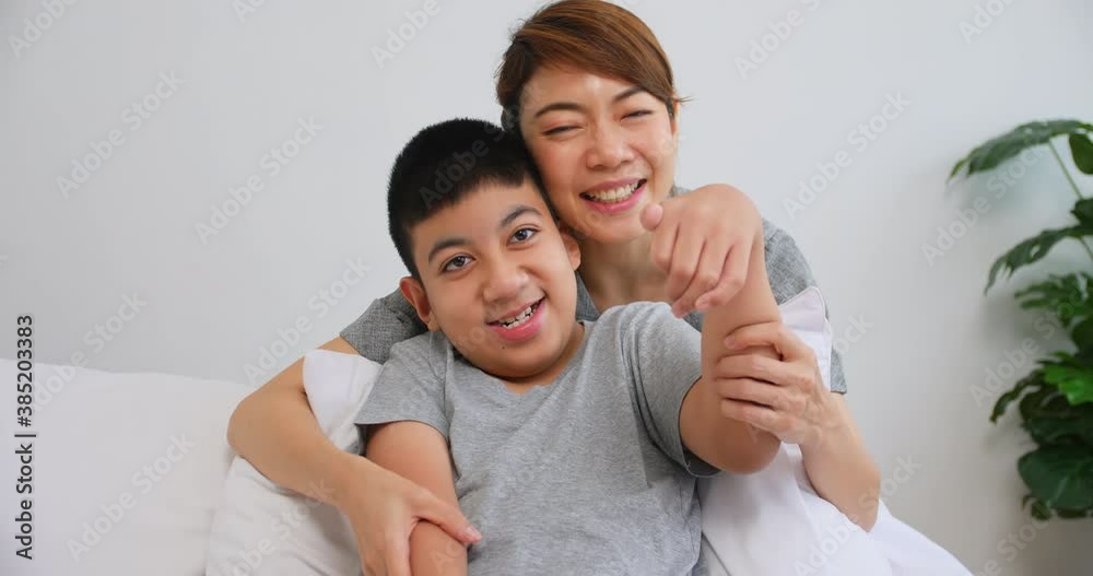Portrait of happy family with mother and disabled son sitting on sofa at home. Portrait of happy family with mother and disabled son sitting on sofa at home.