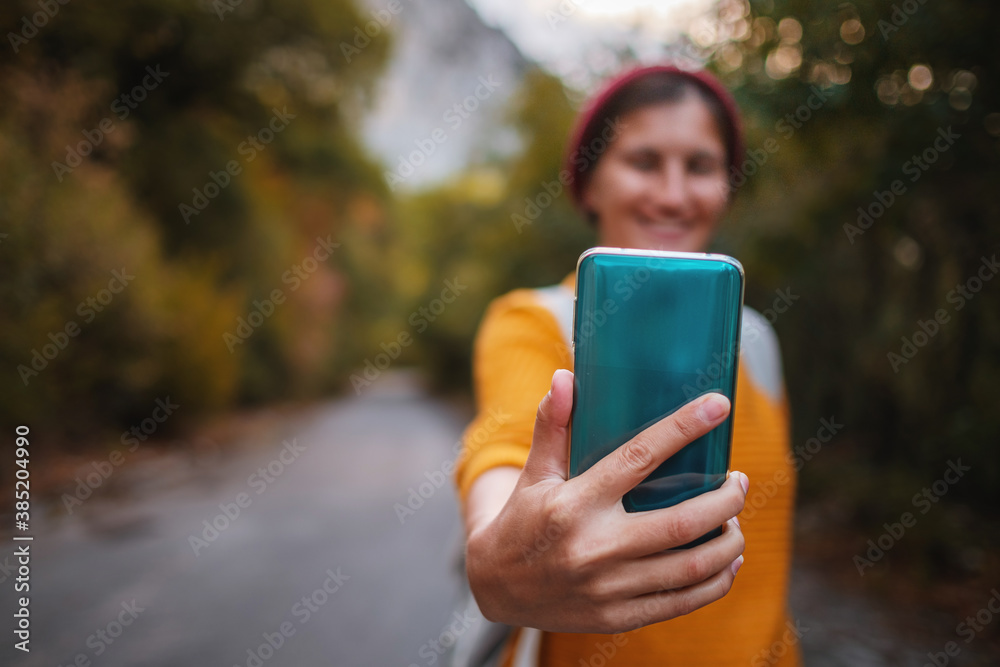 Outdoor fashion photo of young beautiful lady surrounded autumn forest in mountains