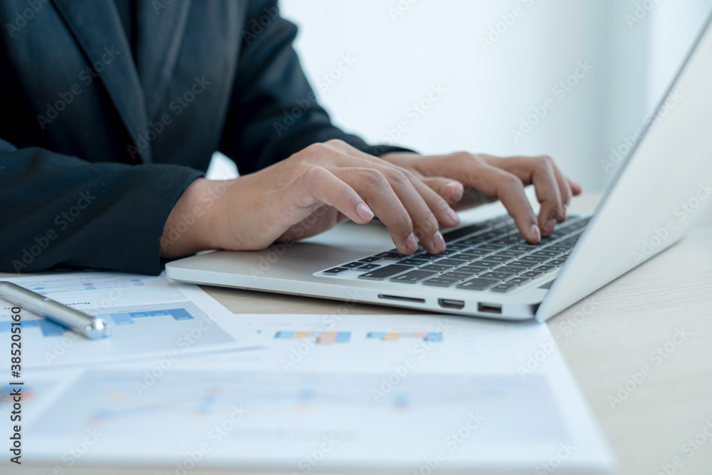 The hand of an accountant woman is analyzing and calculating the financial graph showing the results in the office The hand of an accountant woman is analyzing and calculating the financial graph showing the results in the office