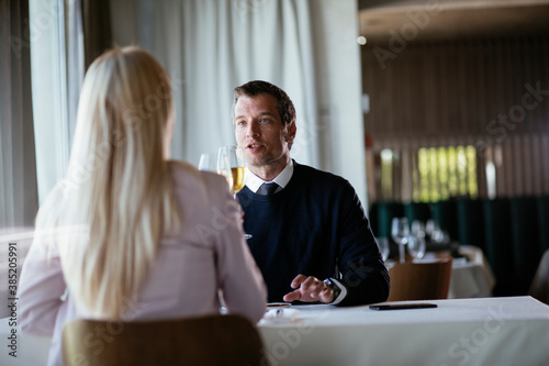 Handsome businessman dressed in the suit drinking wine. Businessman enjoying in the restaurant...