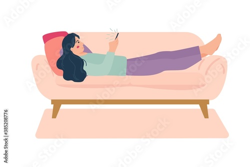 woman lying down on comfy sofa with smartphone playing video, social media. Take a break, lazy weekend concept.