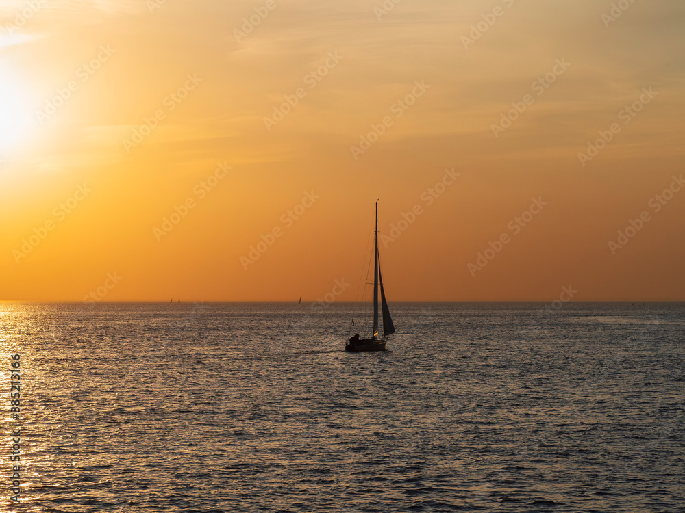 Yacht in calm at sunset. Minimalistic seascape.
