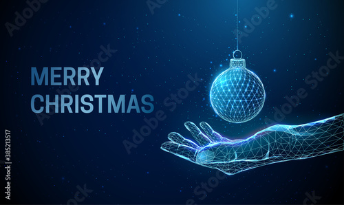Abstract low poly giving hand with Christmas ball.