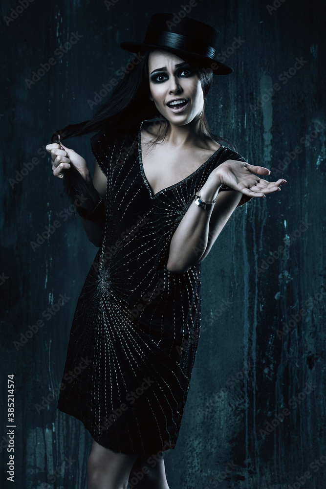 Naklejka premium emotional woman in black dress and hat