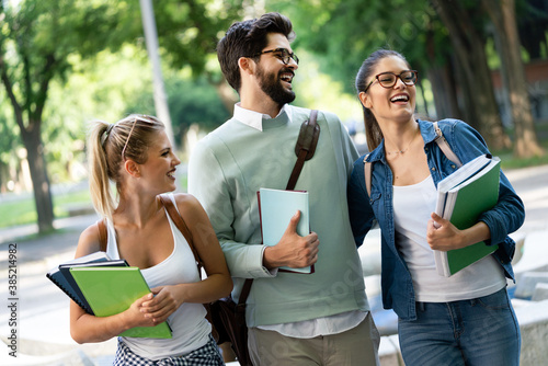 Fotografie Group of happy university students studying together and having fun outdoors