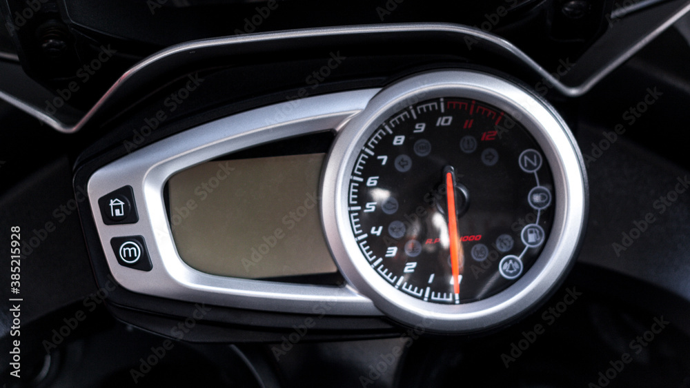 Modern electronic speedometer and pointer tachometer with indicators sports motorcycle on handlebars closeup. Dashboard with odometer, fuel gauge, trip meter and RPM meter of road bike, top view Modern electronic speedometer and pointer tachometer with indicators sports motorcycle on handlebars closeup. Dashboard with odometer, fuel gauge, trip meter and RPM meter of road bike, top view