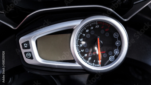 Modern electronic speedometer and pointer tachometer with indicators sports motorcycle on handlebars closeup. Dashboard with odometer, fuel gauge, trip meter and RPM meter of road bike, top view