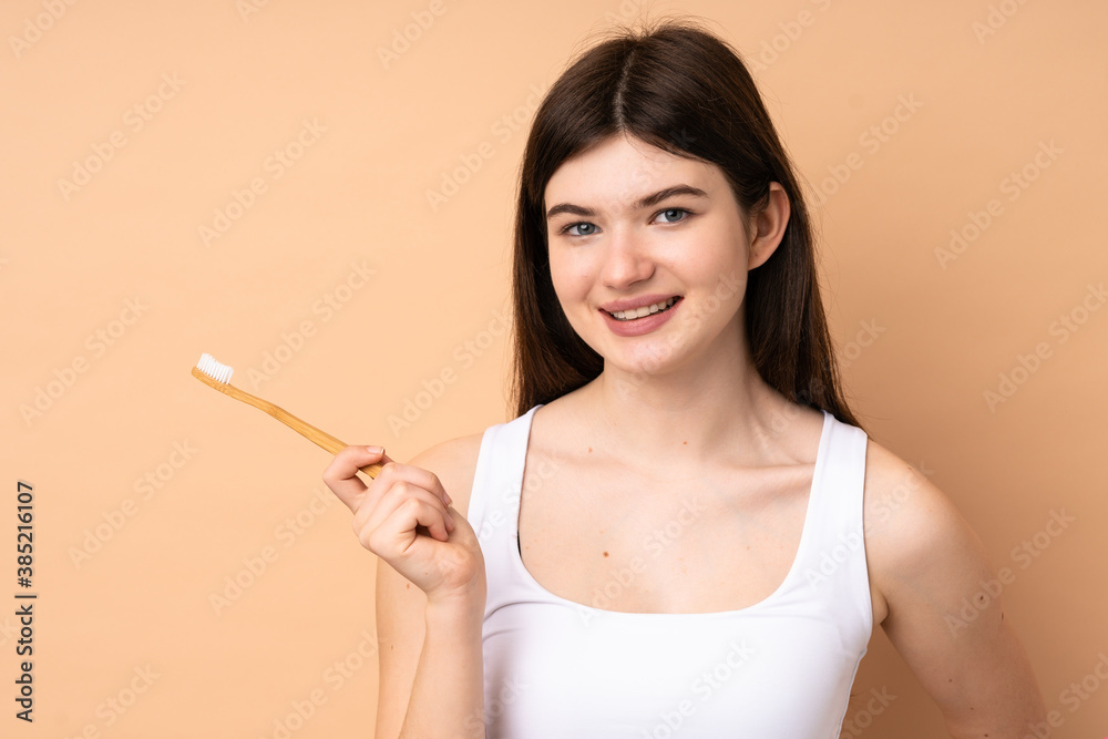 Young Ukrainian teenager girl over isolated background with a toothbrush Young Ukrainian teenager girl over isolated background with a toothbrush
