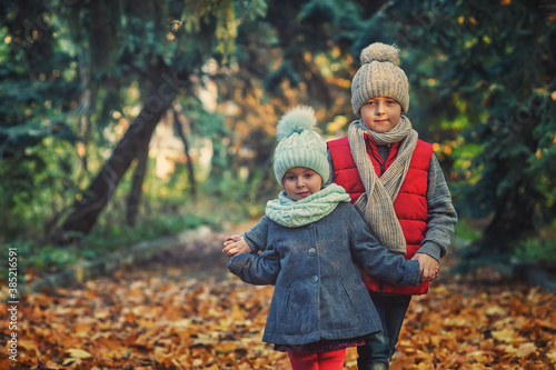 Children on an autumn walk in the park .Happy brother with sister outdoors