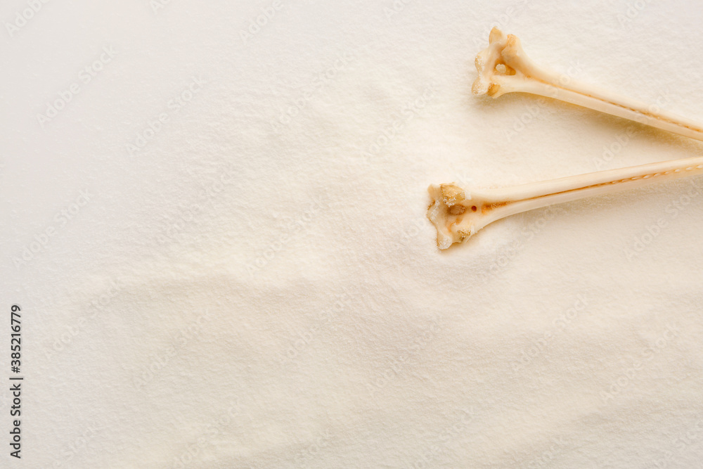 White Collagen powder background with bones. White Collagen powder background with bones.