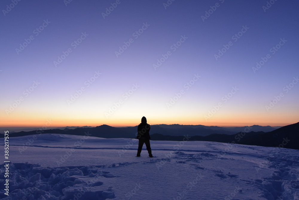 Sunrise from horizon with a silhouette and the mountains at the background
