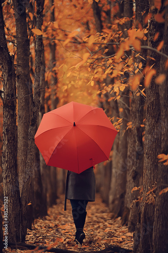 autumn evening woman holds umbrella, october in dark city park, young lonely model with umbrella