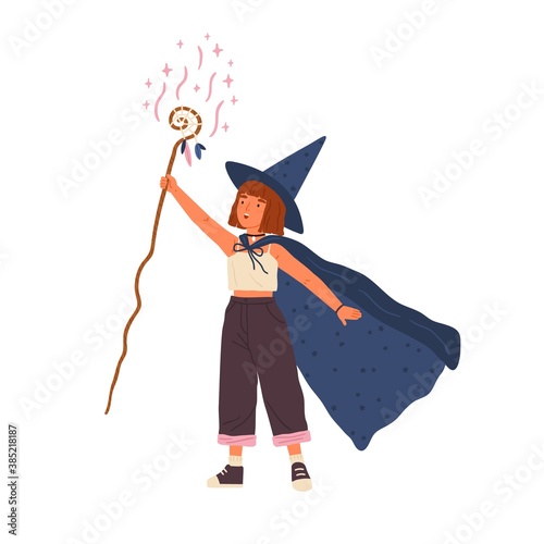 Cute girl wearing witch hat and cloak conjures with magic stick. Young female wizard or sorcerer. Adorable little magician with red hair. Flat vector cartoon illustration isolated on white