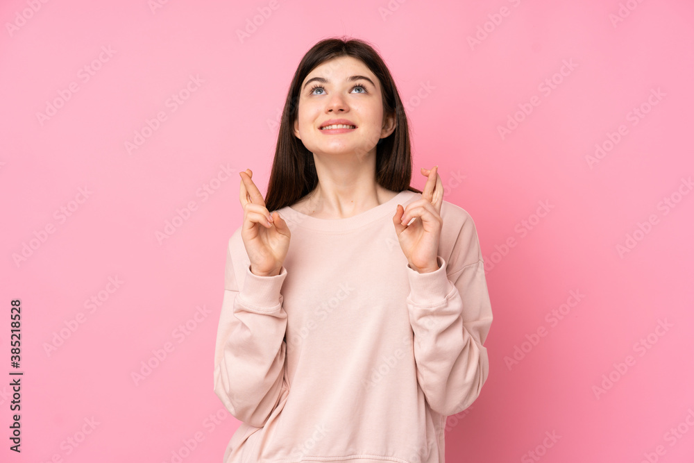 Young Ukrainian teenager girl over isolated pink background with fingers crossing and wishing the best Young Ukrainian teenager girl over isolated pink background with fingers crossing and wishing the best