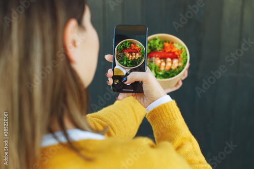 A woman photographs food on her phone. High quality photo.