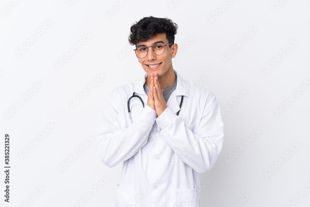 Young Argentinian man over isolated white background wearing a doctor gown and pleading Young Argentinian man over isolated white background wearing a doctor gown and pleading