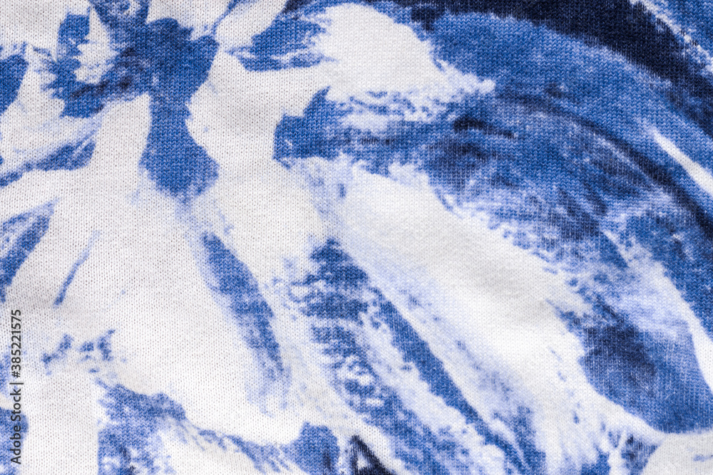 Naklejka premium Tie-dye cotton fabric texture blue and white paint colors. Ancient resist-dyeing textile coloring technique, saturated primary colors, bold patterns, simple motifs, monochromatic color schemes garment
