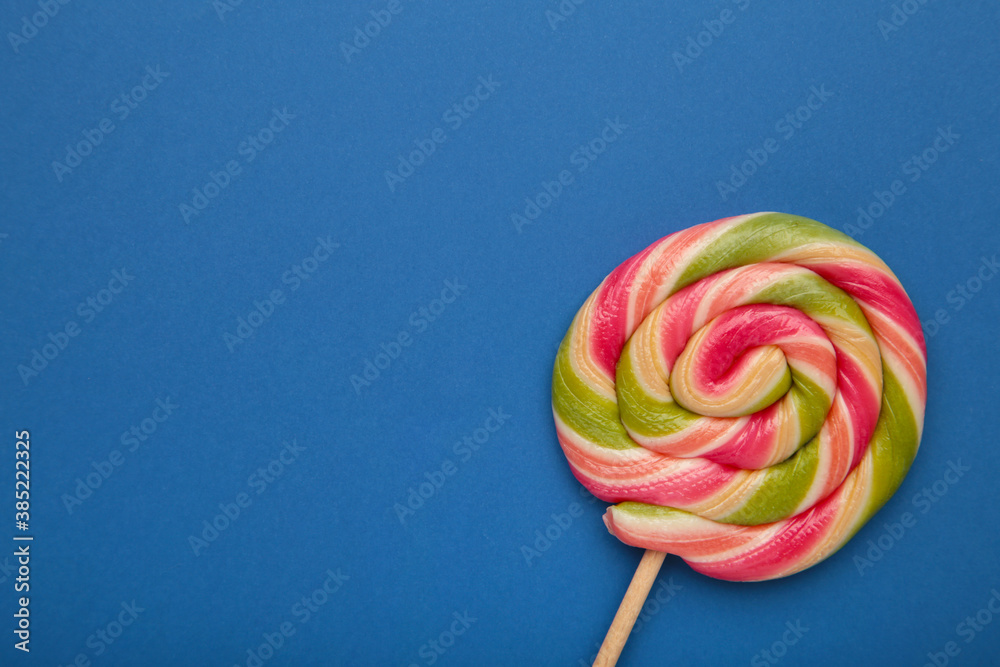 Multicolored lollipop on blue background, view from above. copy space. Multicolored lollipop on blue background, view from above. copy space.