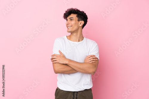 Young Argentinian man over isolated pink background laughing