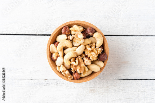 Various kinds of nuts in bowl on wooden background. Top view