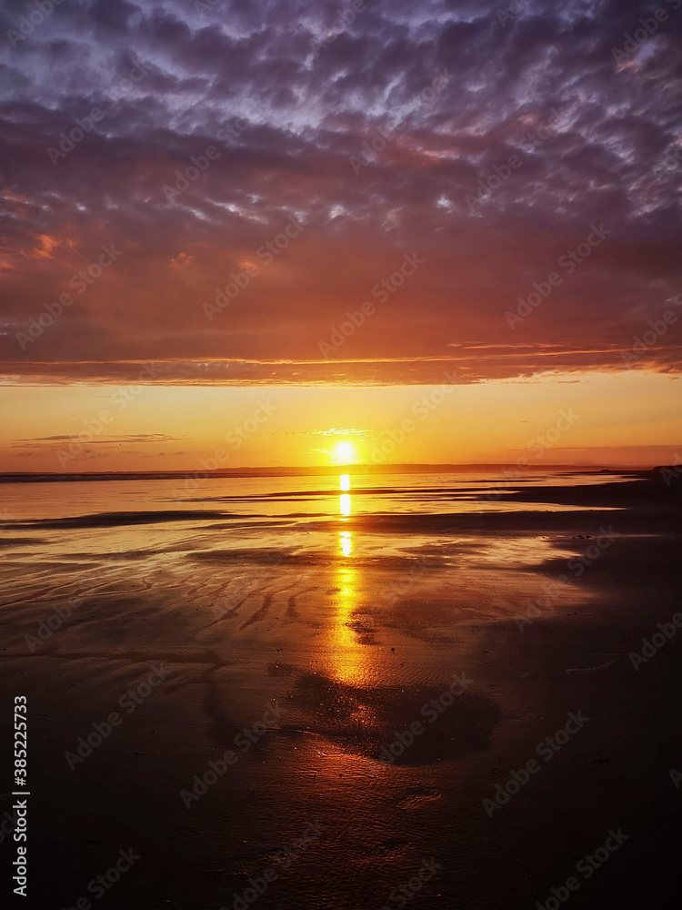 Dramatic sunset on Cefn Sidan beach with Cirrostratus clouds - is a long sandy beach, its dunes form the outer edge of the Pembrey Burrows between Burry Port and Kidwelly.