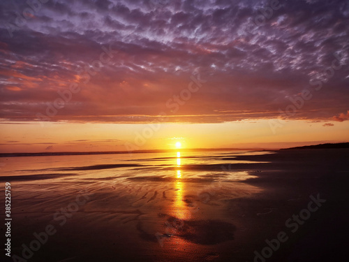 Dramatic sunset on Cefn Sidan beach with Cirrostratus clouds - is a long sandy beach, its dunes form the outer edge of the Pembrey Burrows between Burry Port and Kidwelly. photo