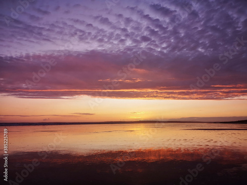 Dramatic sunset on Cefn Sidan beach with Cirrostratus clouds - is a long sandy beach, its dunes form the outer edge of the Pembrey Burrows between Burry Port and Kidwelly. photo