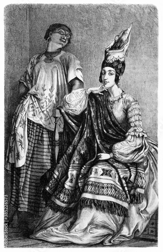 vertical full body portrait of Senegalese lady in traditional costume and her maidservant indoor. Ancient grey tone etching style art by Boulanger, published on Le Tour du Monde, Paris, 1861 © Mannaggia