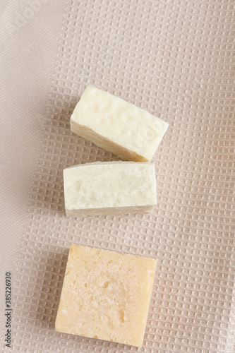 a stack of handmade soap on a beige fabric background, natural spa cosmetics. flat lay, copy space