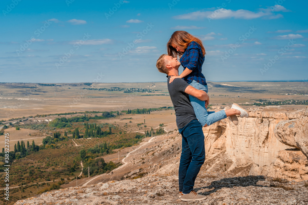 Romantic couple on the edge of a cliff on a White rock in the Crimea, a man picked up a woman