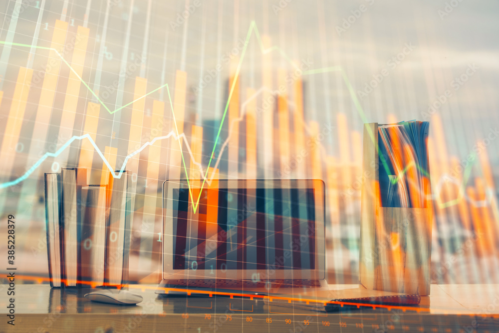 Stock market chart hologram drawn on personal computer background. Multi exposure. Concept of investment. Stock market chart hologram drawn on personal computer background. Multi exposure. Concept of investment.