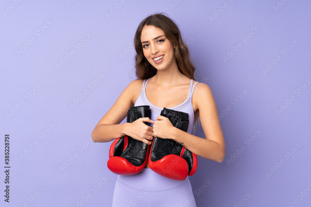 Young sport woman over isolated purple background with boxing gloves Young sport woman over isolated purple background with boxing gloves