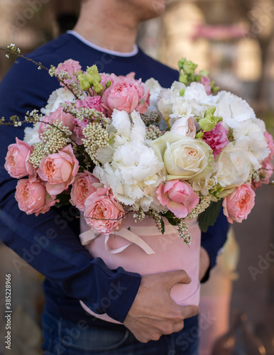 Fototapeta Naklejka Na Ścianę i Meble -  Bouquet in box. Gift box with beautiful flower. Woman holding big beautiful blossoming box bouquet of fresh roses, carnation, peonies, eustoma and others.