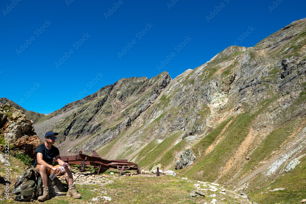 Fototapeta premium hiker resting and drinking water in the mountain